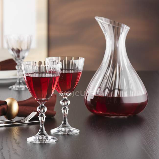 Caraffa e bicchieri di vino rosso in tavola — Foto stock