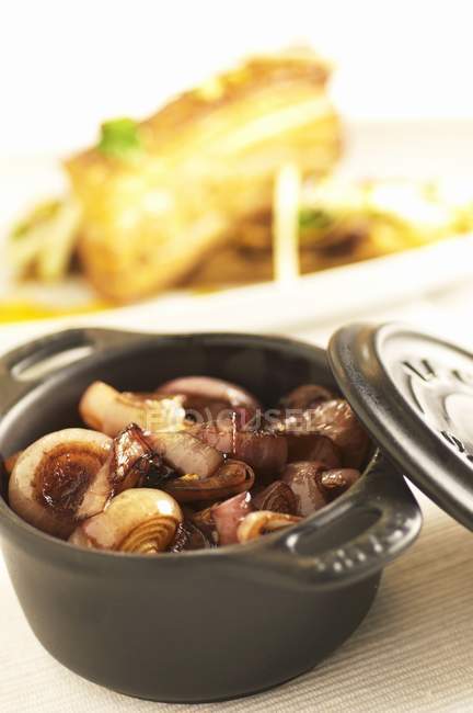 Shallots with roasted pork belly — Stock Photo