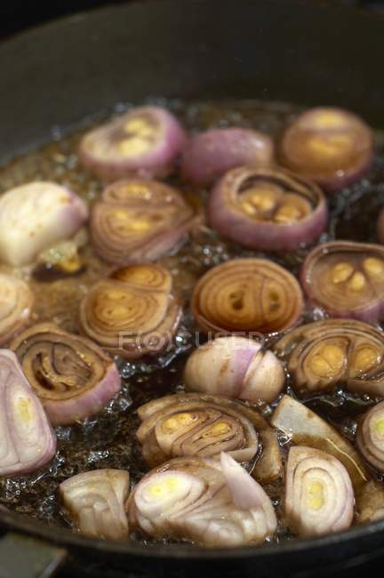 Échalotes sautées dans une casserole — Photo de stock