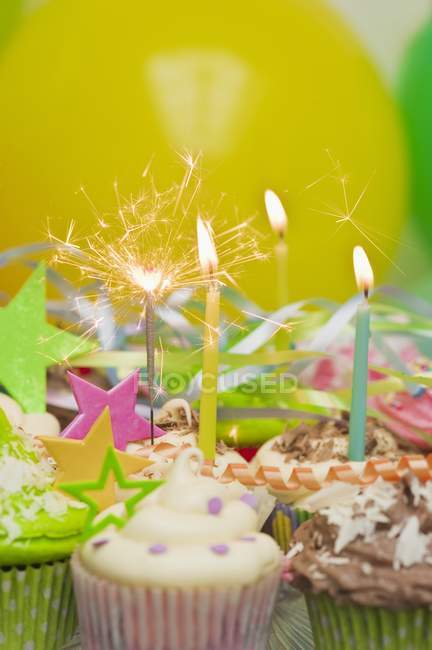 Party cupcakes with lit candles — Stock Photo