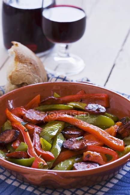 Peperoni con chorizo in piatto rosso — Foto stock