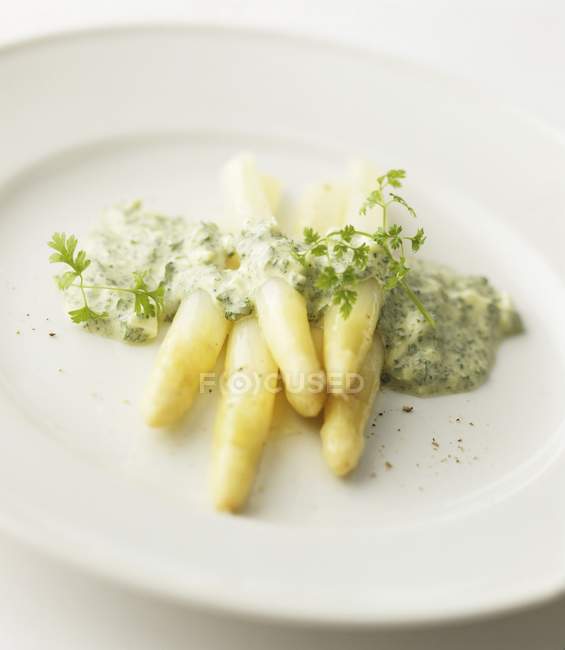 Asparagi bianchi con salsa di cerfoglio su piatto bianco — Foto stock