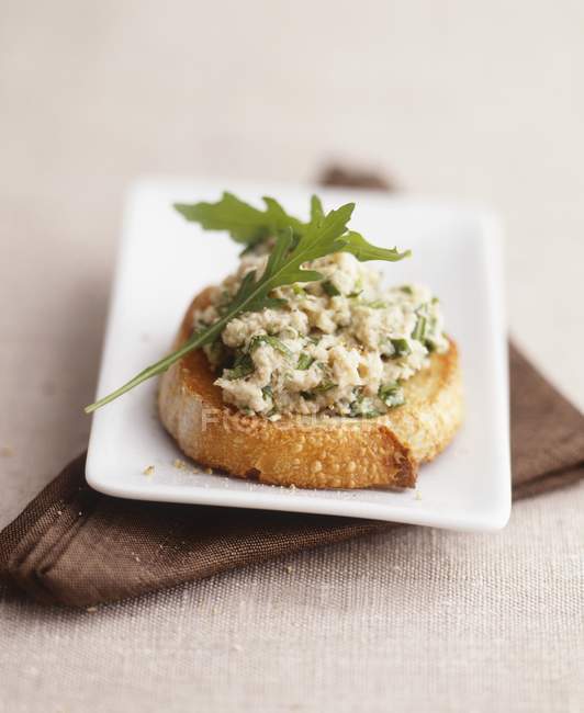 Closeup view of Crostini with chicken and rocket topping — Stock Photo