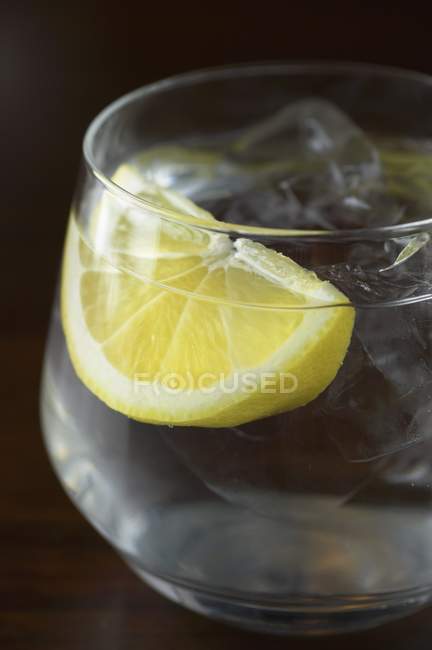 Glass of water with wedge of lemon — Stock Photo