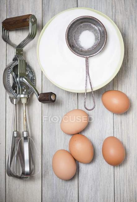 Rotary hand whisk with eggs and sugar — Stock Photo