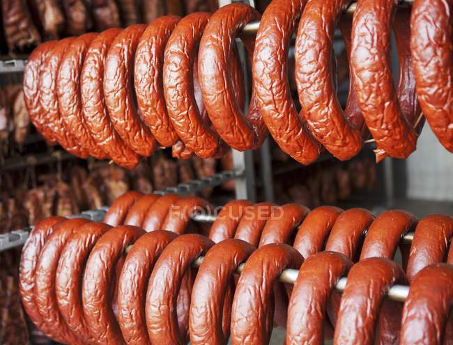 Saucisses suspendues dans la maison de fumée — Photo de stock