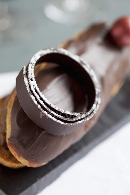 Крупним планом шоколадне прикраса ручної роботи над еклером — стокове фото
