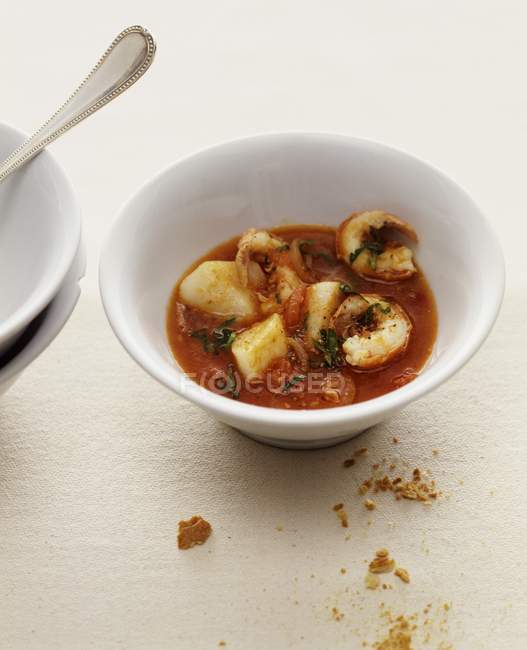 Tomato soup with fish and prawns  on white plate — Stock Photo