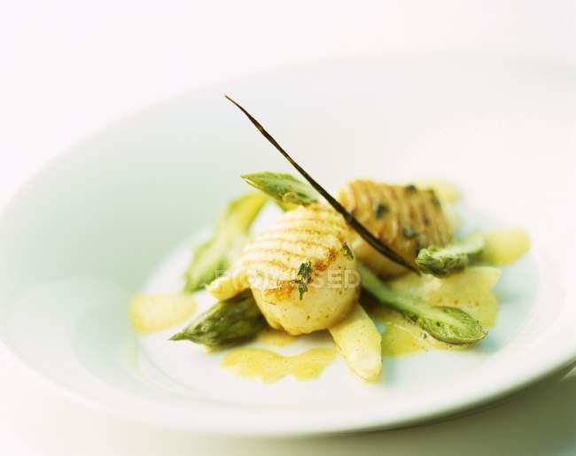 Grilled scallops on asparagus  on white plate — Stock Photo