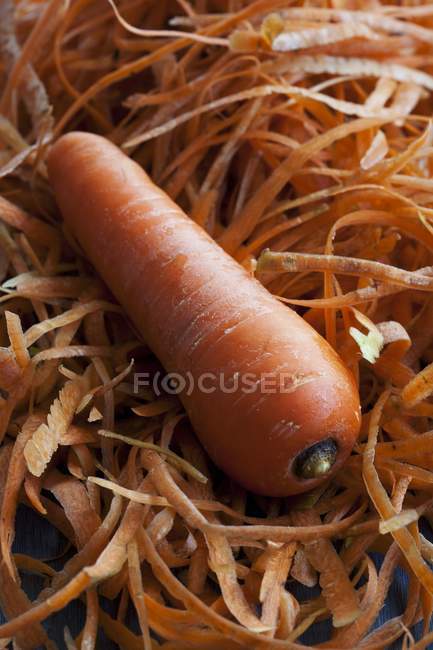 Fresh carrot on peelings — Stock Photo