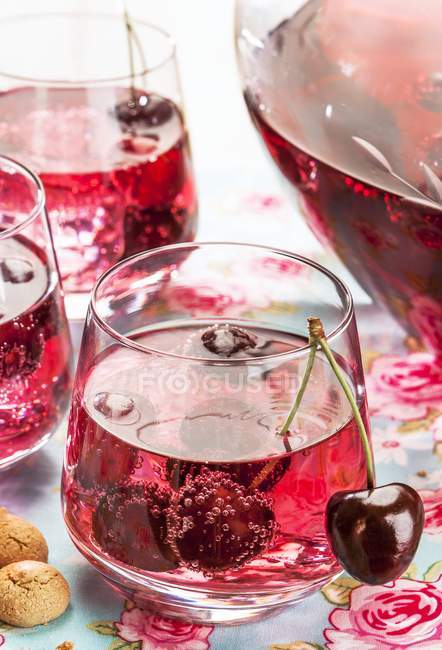 Cherry and amaretto punch in glasses and jug — Stock Photo