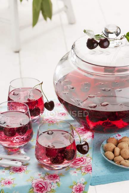 Cherry and amaretto punch in glasses and jug — Stock Photo