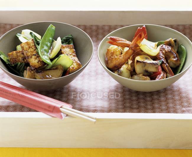 Tofu stir-fry and Shrimp stir-fry in bowls in crate — Stock Photo