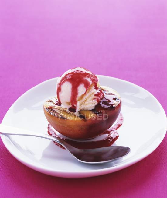 Grilled peach half with vanilla ice cream — Stock Photo