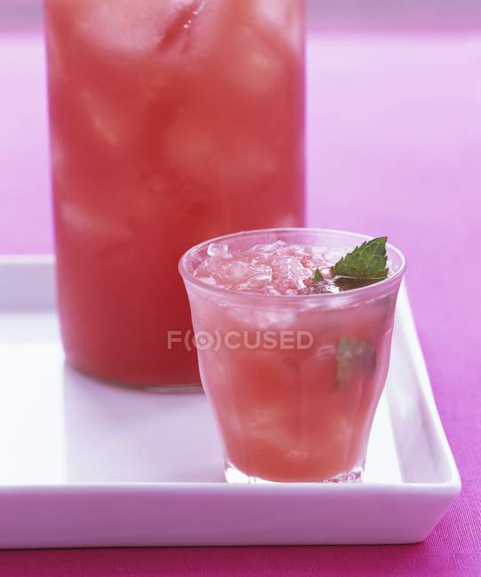 Closeup view of blood orange drink with ice cubes and mint — Stock Photo