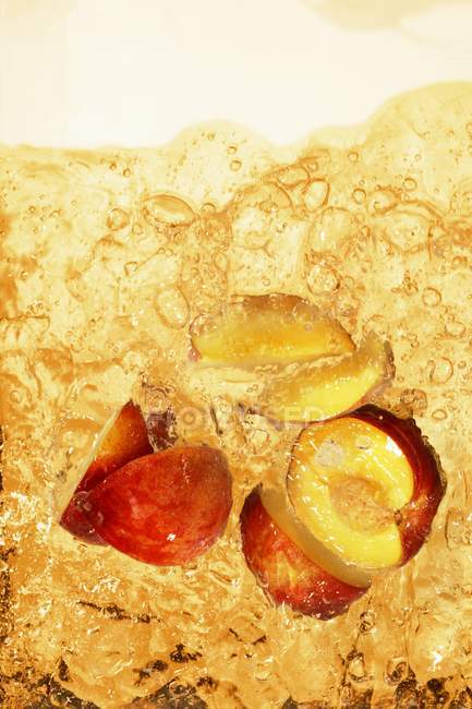 Персиковый чай со льдом и кусочками персика — стоковое фото