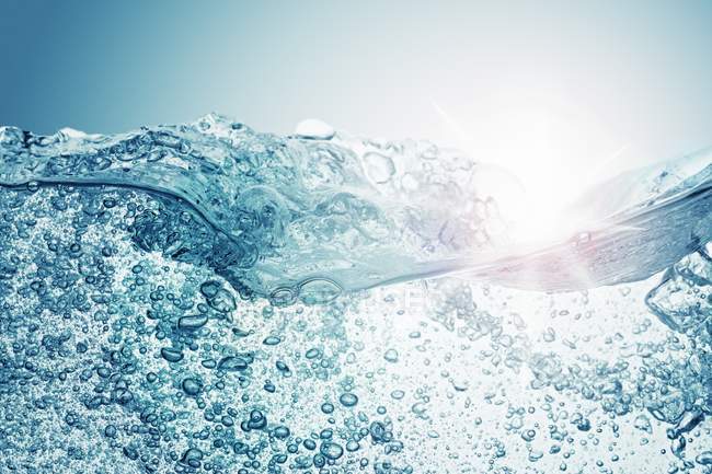 Closeup view of moving water surface with air bubbles — Stock Photo