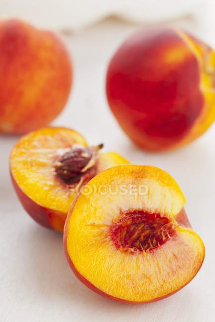 Персики с половинками — стоковое фото