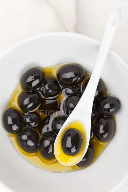 Aceitunas negras en aceite de oliva - foto de stock
