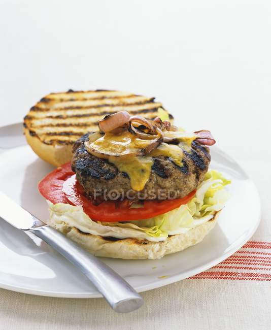 Barbecued cheeseburger with tomatoes — Stock Photo