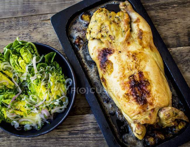 Whole roasted chicken stuffed with salad — Stock Photo