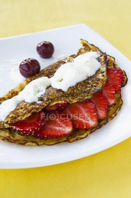 Crepe with strawberries and cream — Stock Photo