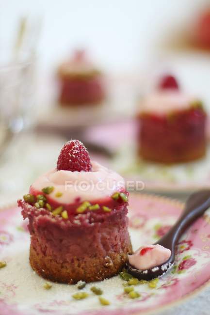 Raspberry cheesecakes with chopped pistachios — Stock Photo