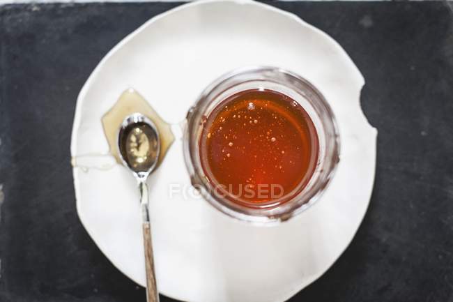Tarro de miel y una cuchara - foto de stock