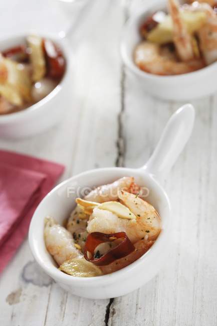 Garlic prawns with chilli in bowls over wooden surface — Stock Photo