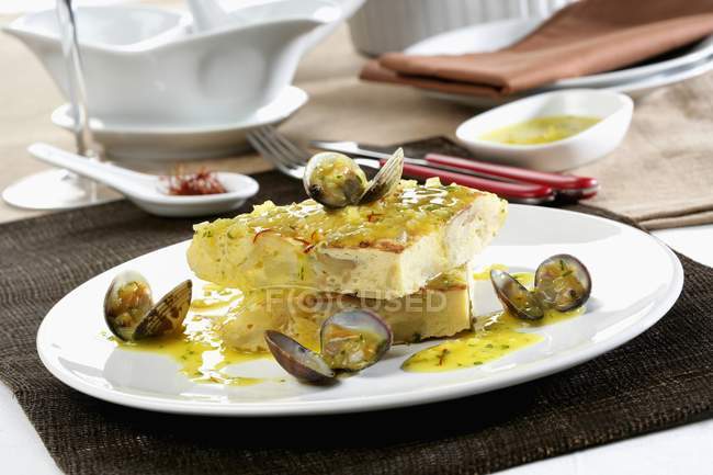 Тушкована тортилья з молюсками на білій тарілці — стокове фото