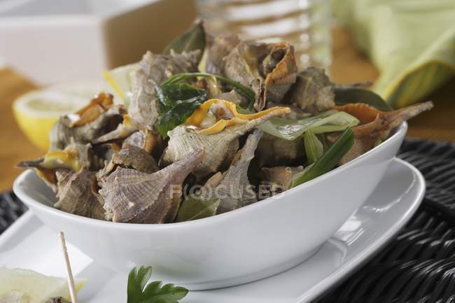 Cooked snails  on white bowl over plate — Stock Photo