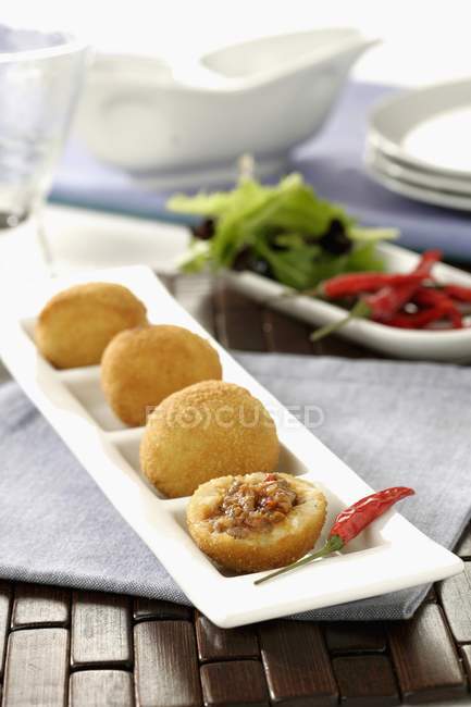 Potato pumps on white small plate in row — Stock Photo