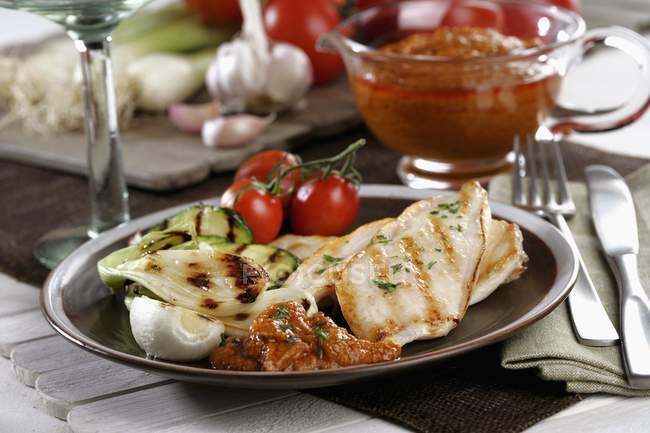 Gegrilltes Huhn und Gemüse mit Rommesco auf schwarzem Teller — Stockfoto