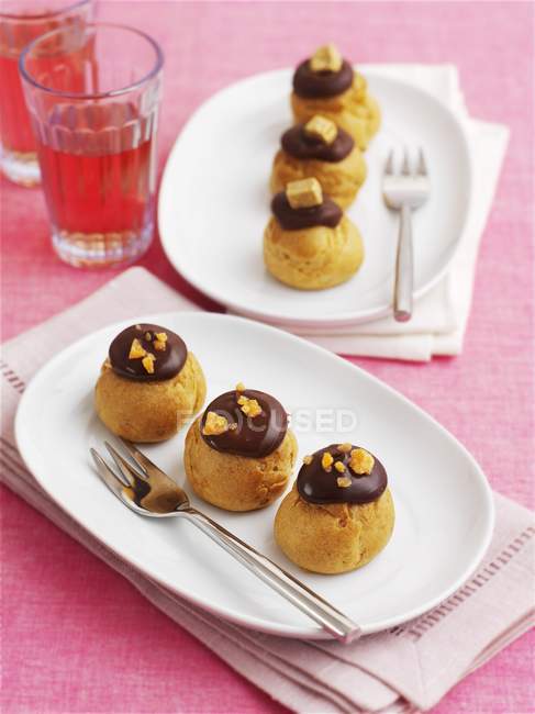 Profiteroles with chocolate topping — Stock Photo