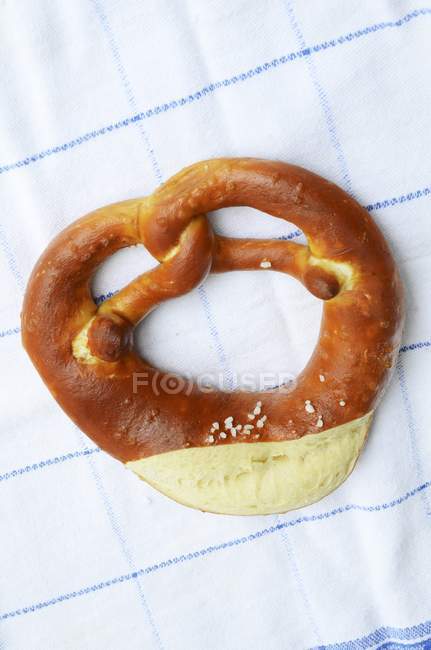 Lye pretzel on a tea towel — Stock Photo