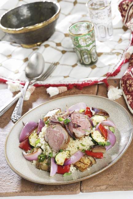 Couscous with vegetables and pork tenderloin — Stock Photo