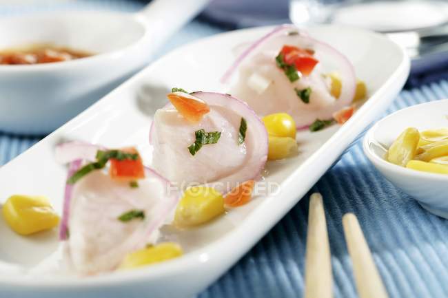 Closeup view of Peruvian Ceviche with sweet corn on white dish — Stock Photo