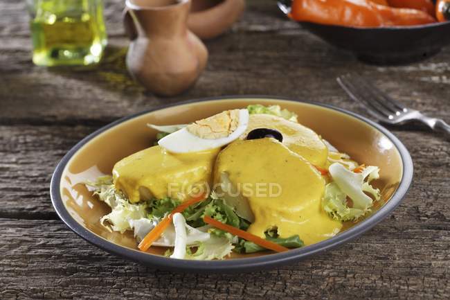 Peruvian potatoes on plate over rustic wooden surface — Stock Photo