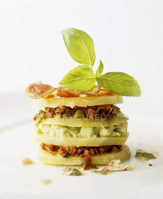 A tower of kohlrabi with avocado and dry-cured ham on white surface — Stock Photo