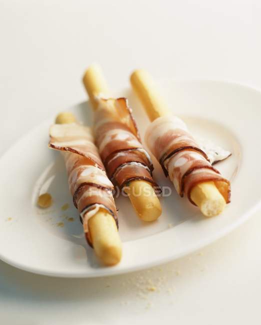 Grissini wrapped in ham — Stock Photo