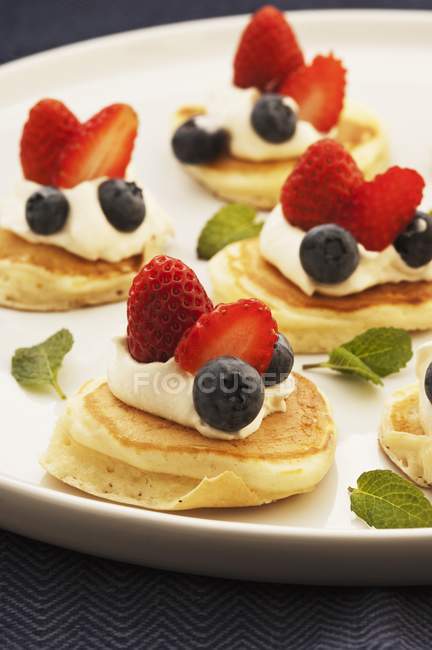 Closeup view of pikelets with cream and berries on platter — Stock Photo