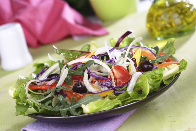 Feuilles de salade mélangées avec des légumes tranchés — Photo de stock