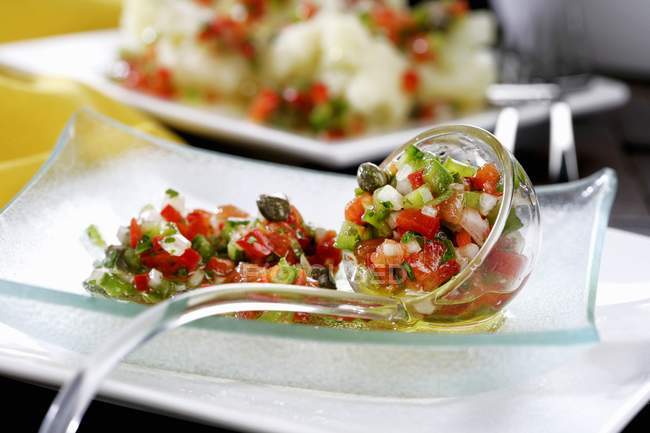 Vegetable vinaigrette with tomatoes, peppers, capers and chillies on glass plate — Stock Photo