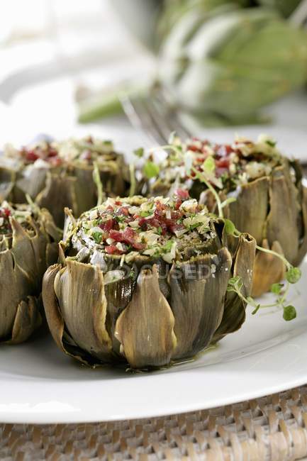 Alcachofas rellenas al horno en plato blanco - foto de stock