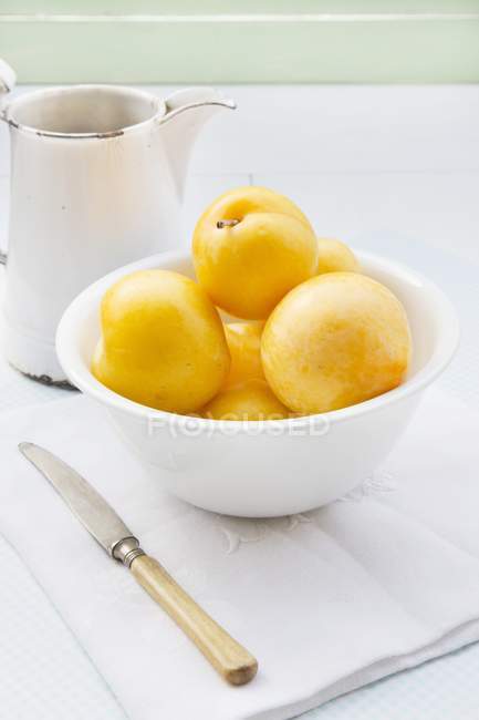 Ameixas amarelas em tigela branca — Fotografia de Stock