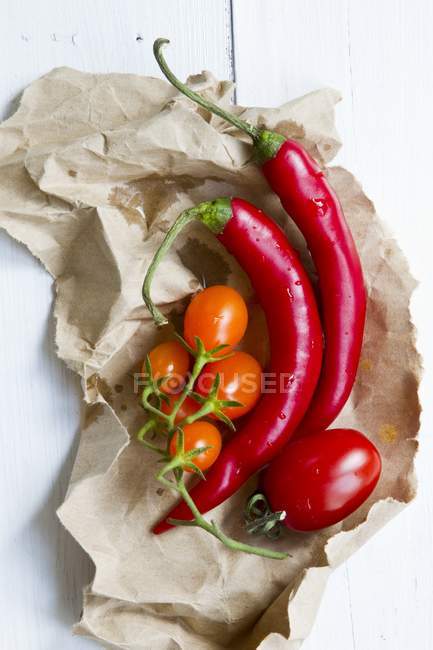 Red chillies and orange tomatoes — Stock Photo