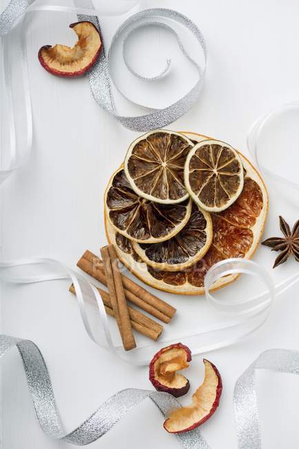 Top view of dried fruit with cinnamon sticks and ribbons — Stock Photo