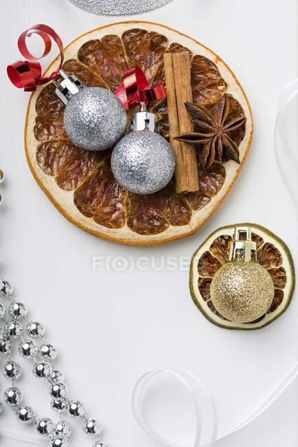Closeup top view of dried fruit with cinnamon sticks, star anise and Christmas baubles — Stock Photo