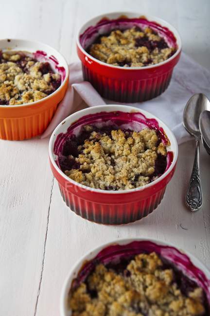 Closeup view of berry Crumbles in bowls with spoons — Stock Photo