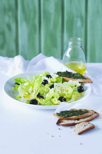 Salada de alface com azeitonas e molho de limão — Fotografia de Stock